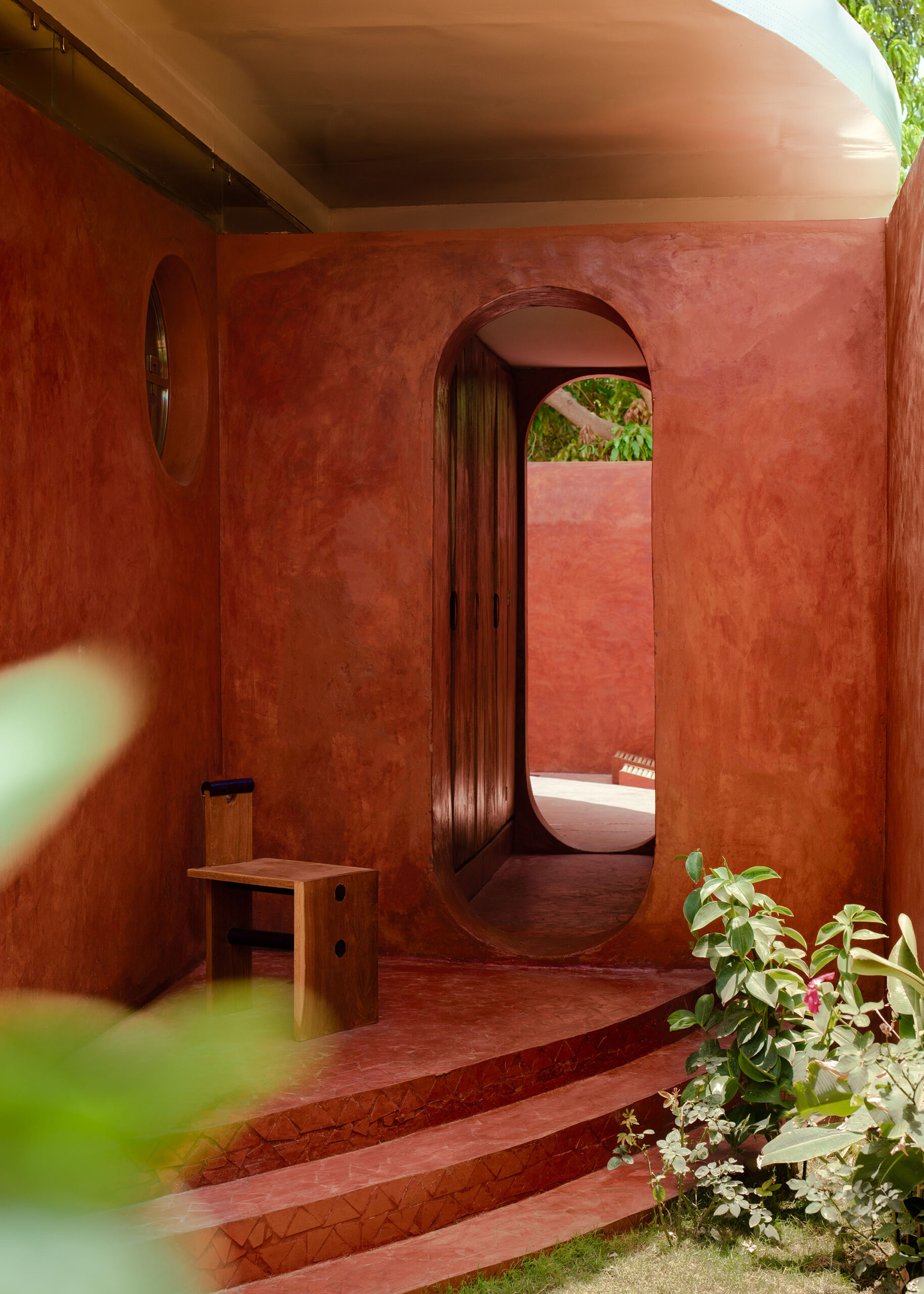 Villa Aram au Sénégal, patio aux murs rouges avec ouverture arquée
